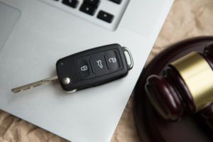 Car key beside a gavel on a laptop, symbolizing the auto theft and theft crimes cases handled by Simmrin Law Group